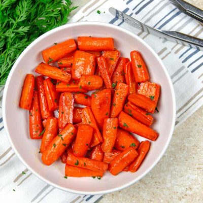 Air fryer carrots in a white bowl with parsley.