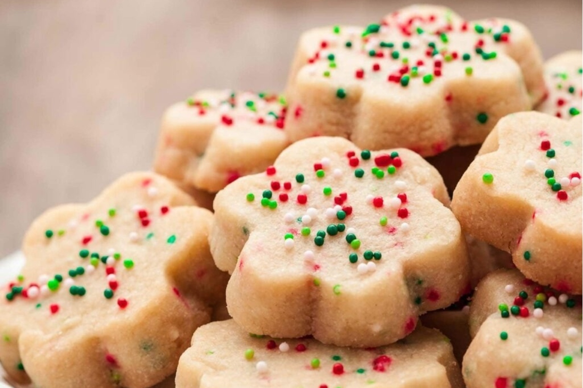 A pile of Christmas cookies with sprinkles on top.