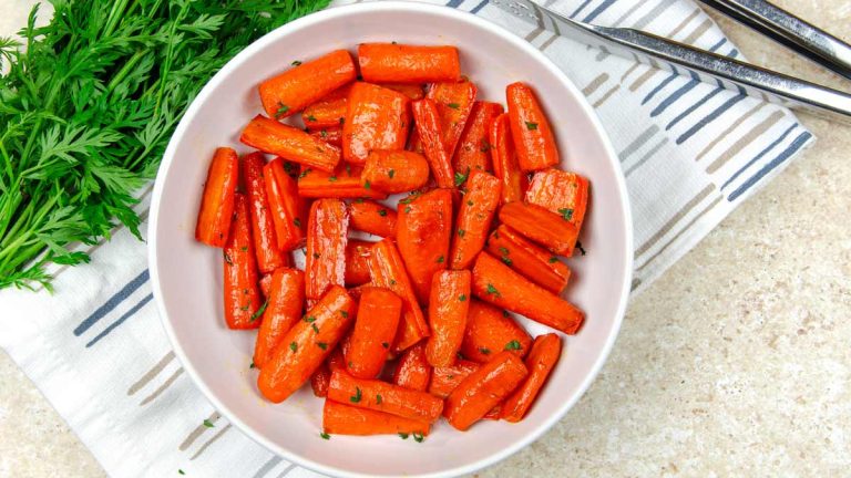 Air fryer carrots in a white bowl with parsley.