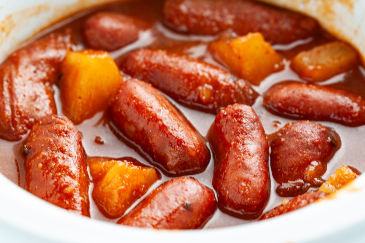 Bite-sized sausages and potatoes served in a white bowl, perfect for game day snacking.