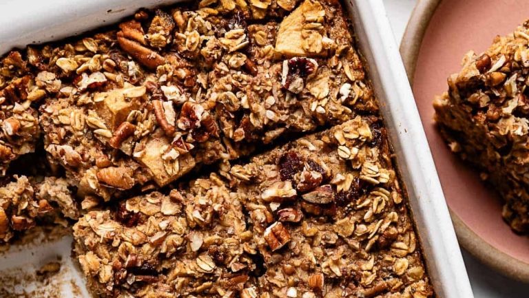 Sweet granola bars in a white dish with a spoon.