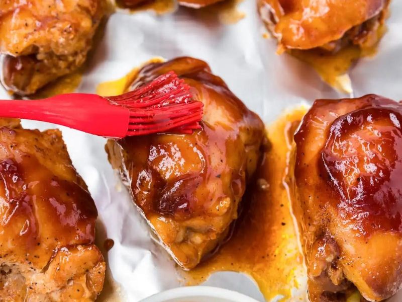 Slow cooker chicken dinners on a baking sheet with a red spatula.