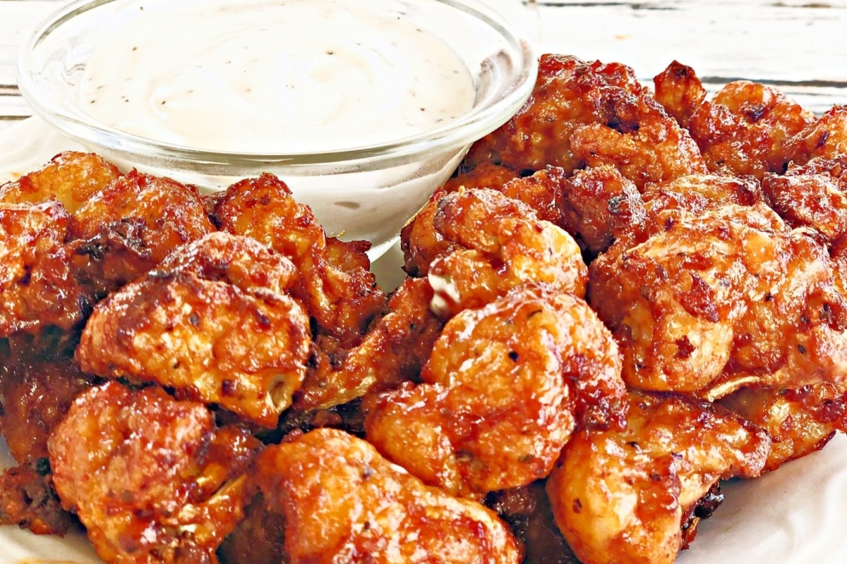 Bite-sized fried cauliflower bites with a tangy dipping sauce, perfect for game day snacks.