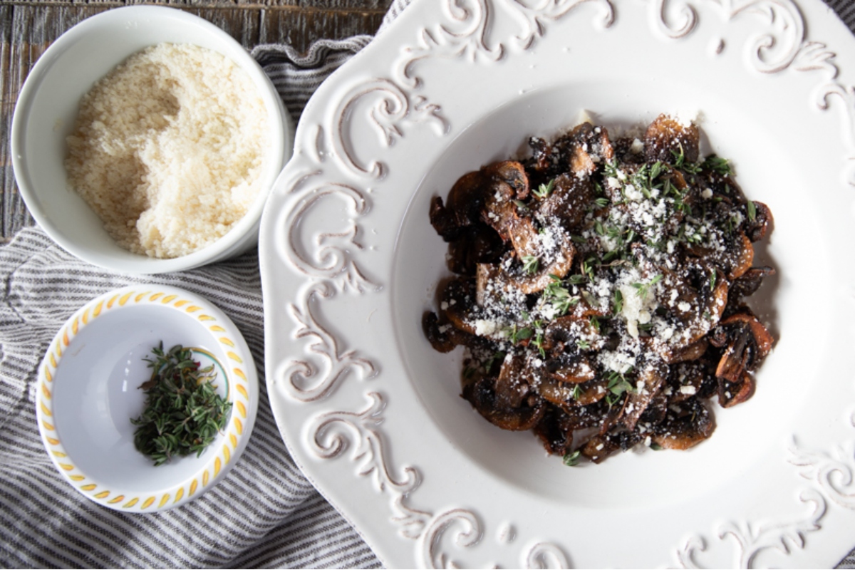 Air fried mushrooms and rice served on a white plate with parmesan.