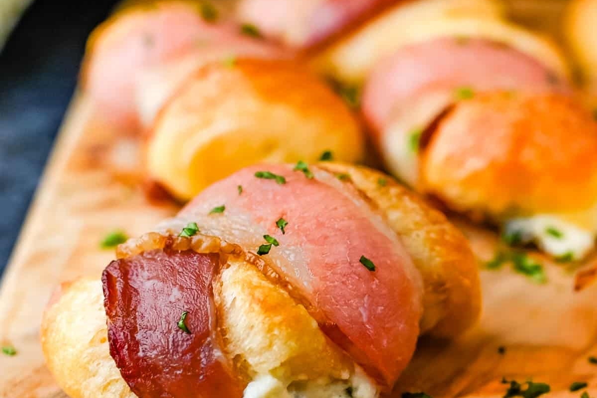 Game day appetizers featuring delicious bacon and cheese rolls presented on a cutting board.