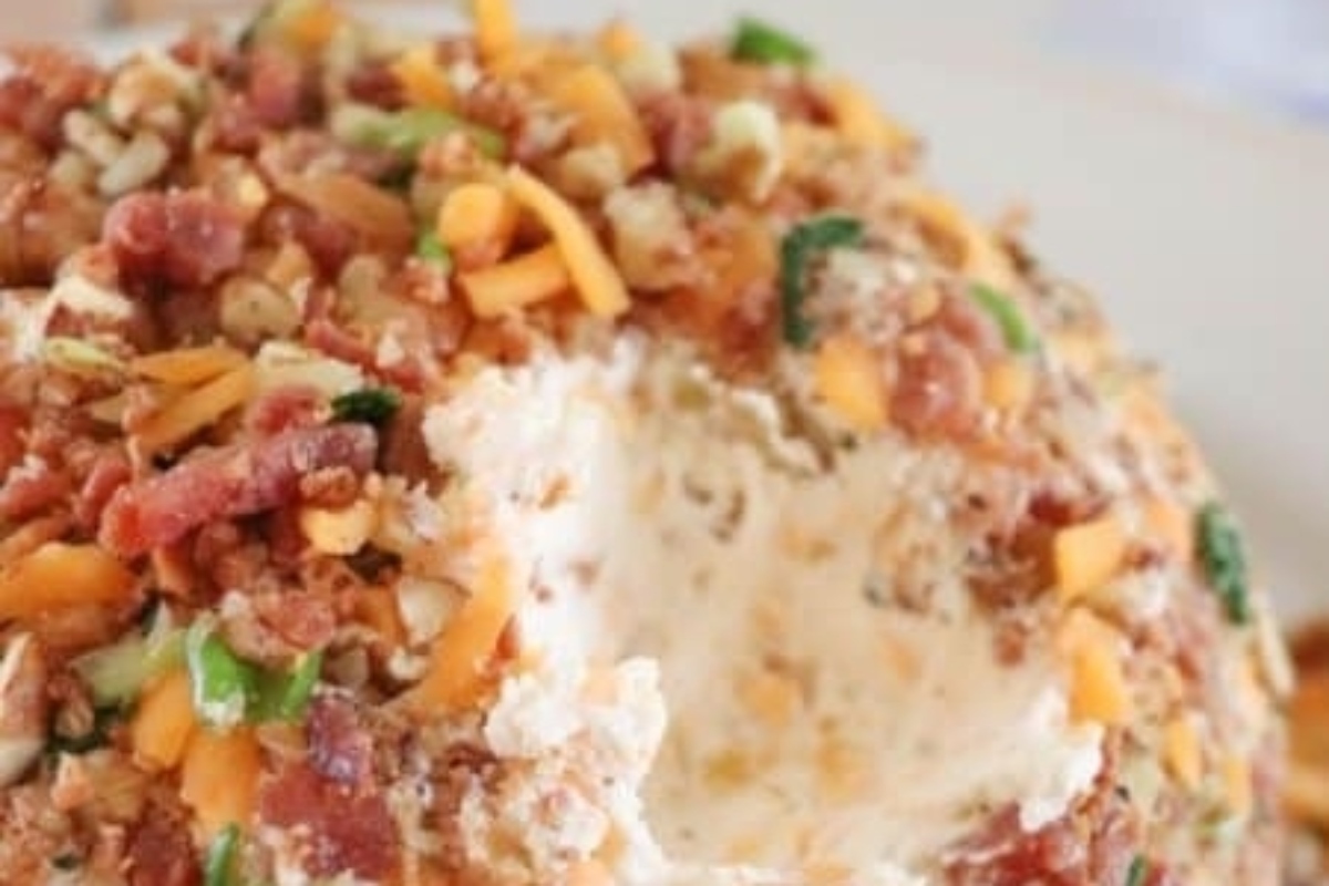 A festive cheese ball covered in bacon and cheese.