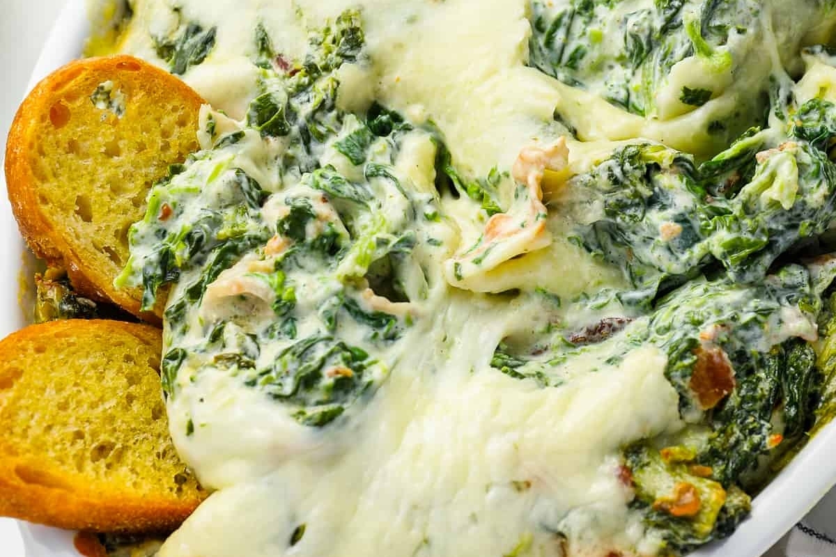 Recipe for spinach and artichoke dip served in a white dish.