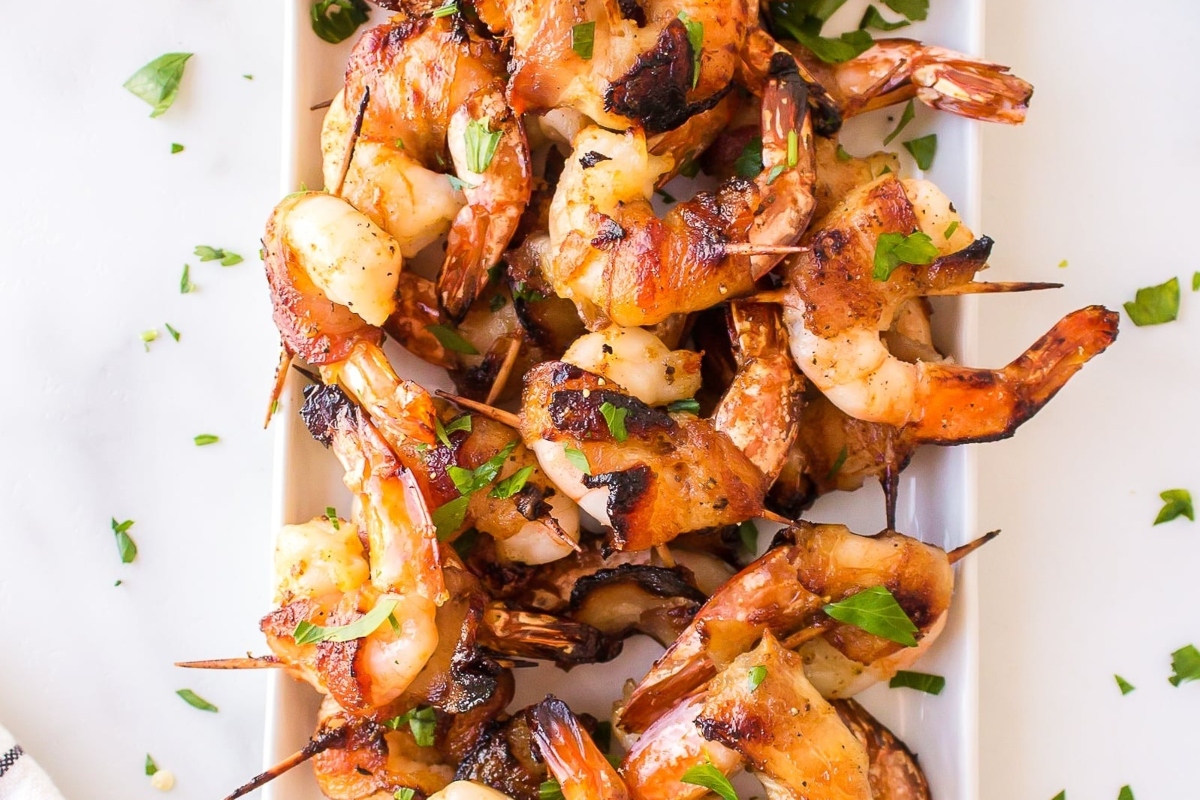 Surf and Turf: Grilled shrimp on skewers served on a white plate.