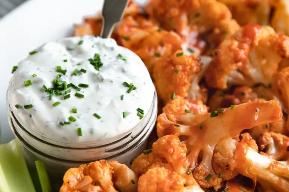Buffalo cauliflower dip, perfect for game day, with bite-sized cauliflower and celery.