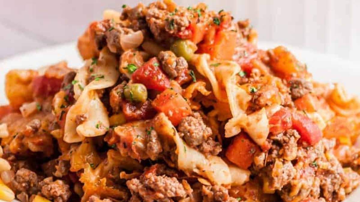 A comforting plate of pasta with meat and vegetables, perfect for a shared meal.