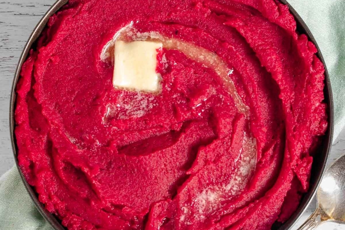 Easy beet recipes - Mashed beets in a pan with butter and a spoon.