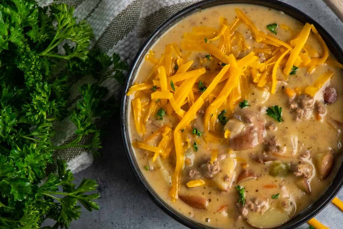 Cheesy potato soup in a skillet with parsley.