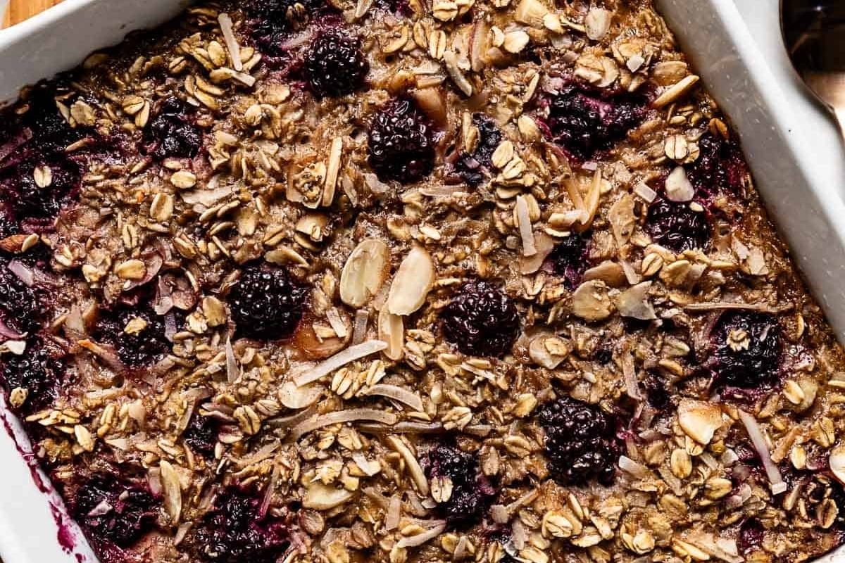 Christmas-themed blackberry oatmeal in a white dish with a spoon.