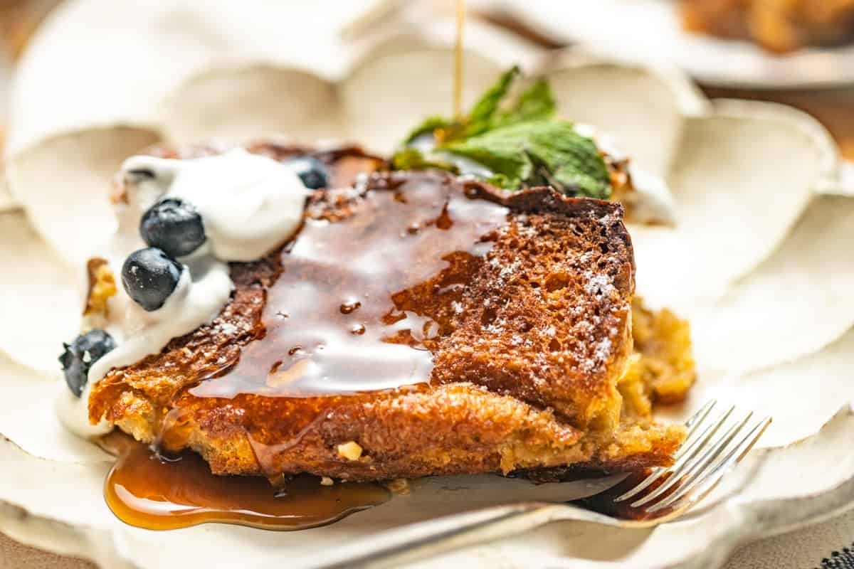 A breakfast slice of French toast with blueberries on a plate.