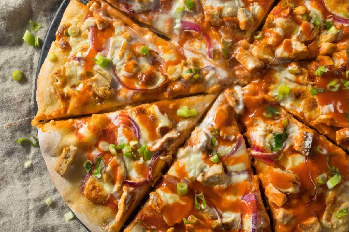 A mouthwatering slice of buffalo chicken pizza on a plate, perfect for game day.