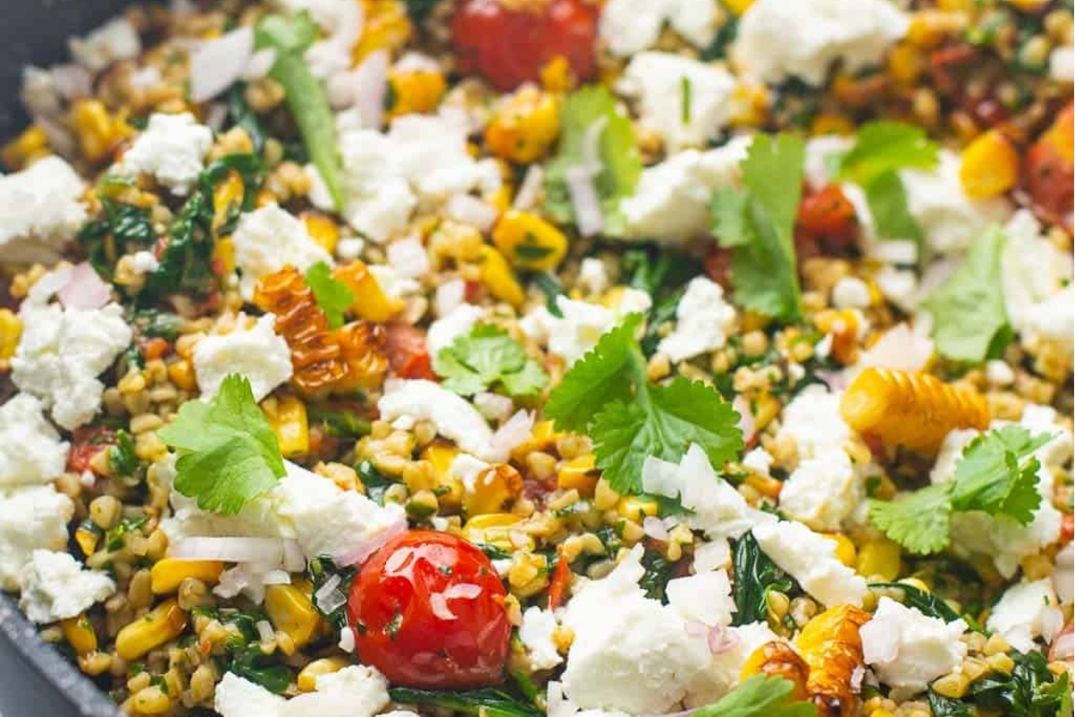 A hearty skillet filled with quinoa, tomatoes and feta cheese.