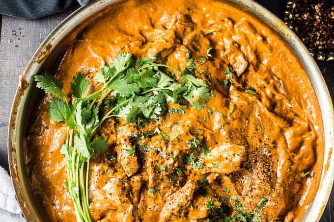 A skillet with a sizzling bowl of chicken tikka masala, one of the most popular curry recipes.