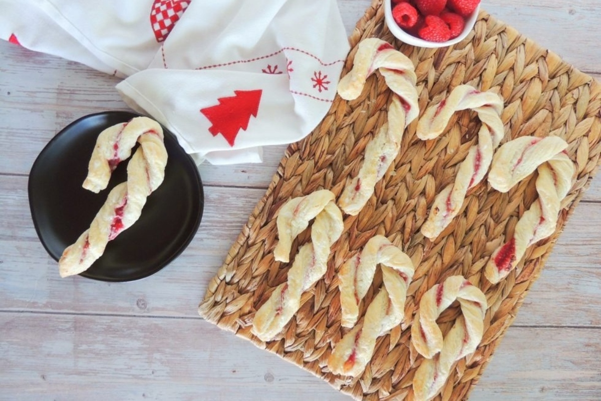 Candy cane twists on a tray with a bowl of raspberries make for the ultimate festive dessert.