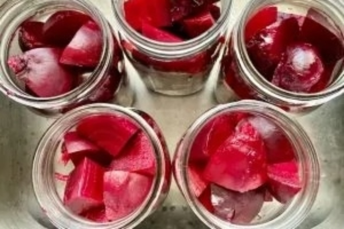 Colorful beets in jars on a counter, ready for some delightful beet recipes.