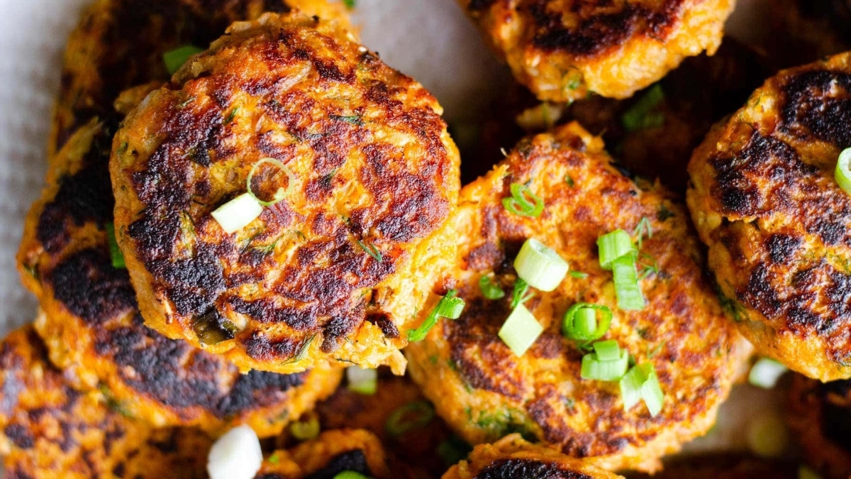 A plate of fried chicken patties on a white plate.