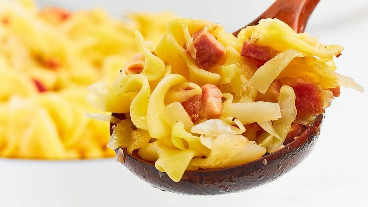A comforting round-up of cabbage and bacon recipes, served with a spoon in a bowl.