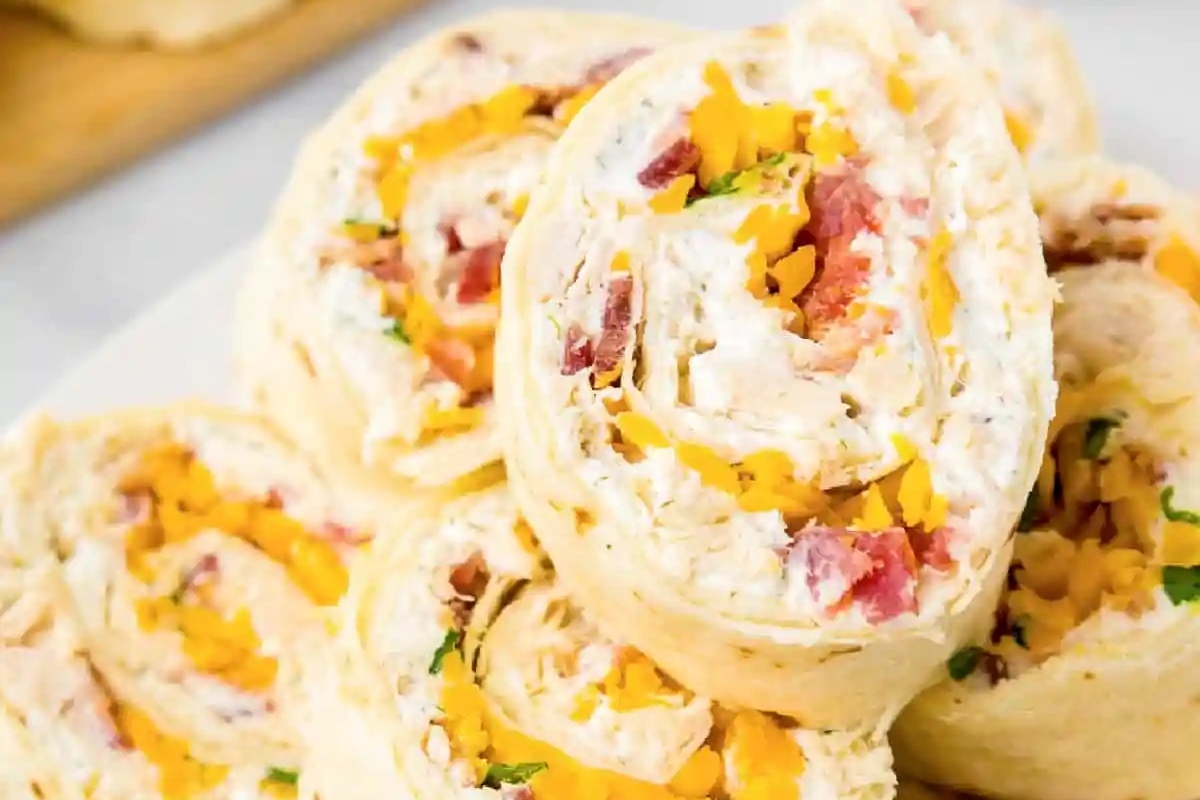 A plate of bite-sized chicken and cheese wraps on a white plate, perfect for game day.