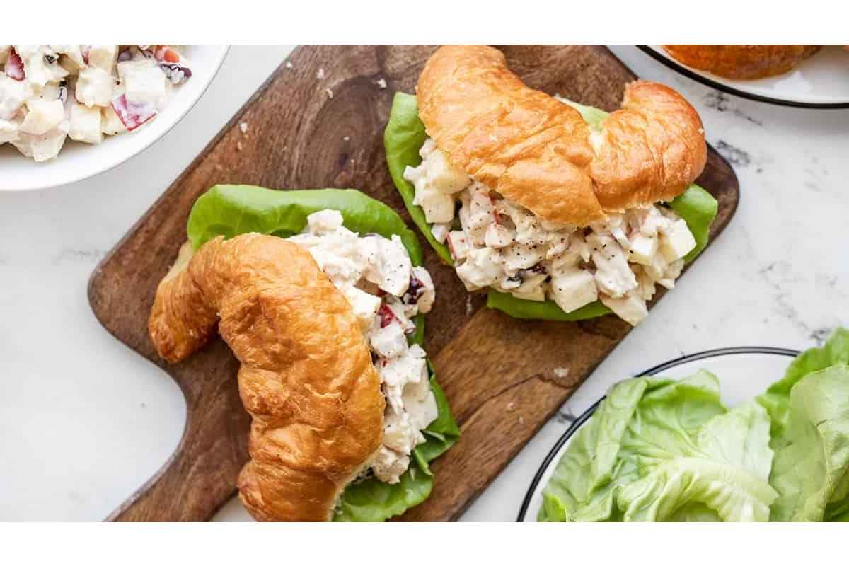 High Protein Chicken salad sandwich on a wooden cutting board, perfect for healthy lunches.