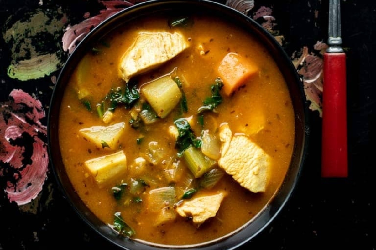 A bowl of chicken stew with vegetables and a fork. This dish is the perfect blend of hearty chicken, tender vegetables, and comforting flavors. The stew is rich in vitamins and nutrients from a
