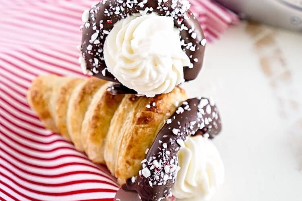 Candy cane chocolate peppermint cones topped with whipped cream and sprinkles.