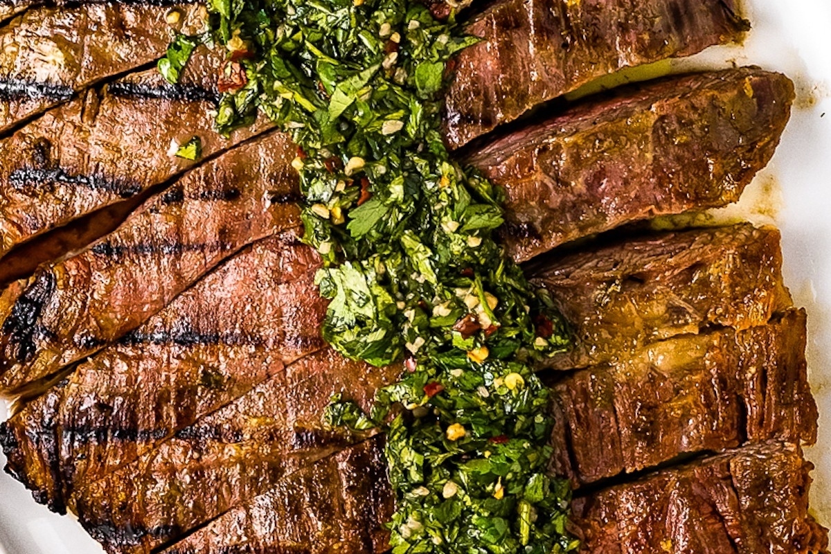 A delicious dinner plate of tender beef steak served with a vibrant green sauce, perfect for Christmas celebrations.