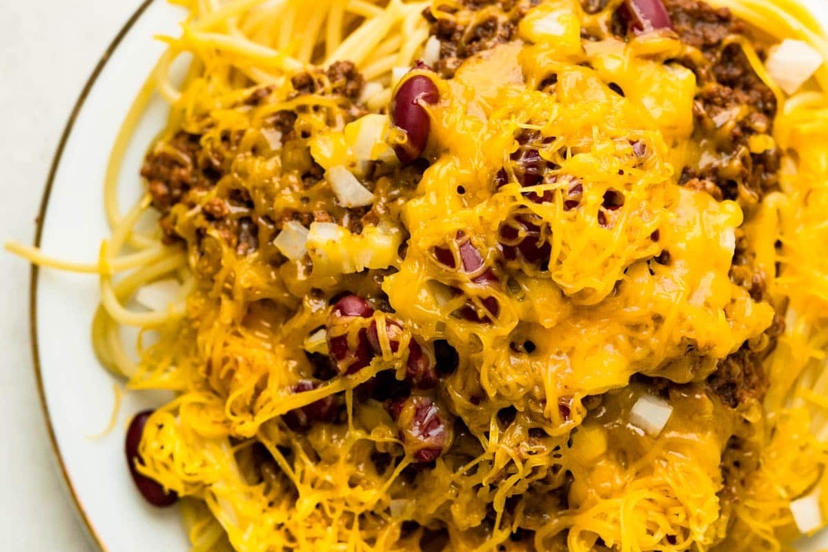 A plate of spaghetti and chili, a delicious combination of flavors and textures, served on a simple white plate.