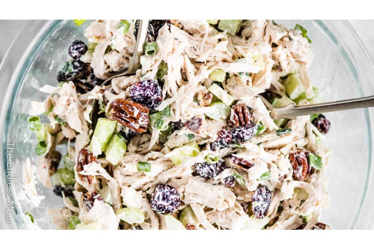 Healthy chicken salad with cranberries and pecans, perfect for lunches or as a high protein option. Served in a glass bowl for an elegant presentation.