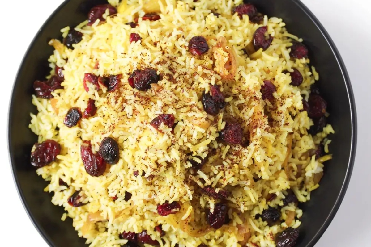 A bowl of rice with cranberries and raisins, perfect for Thanksgiving.