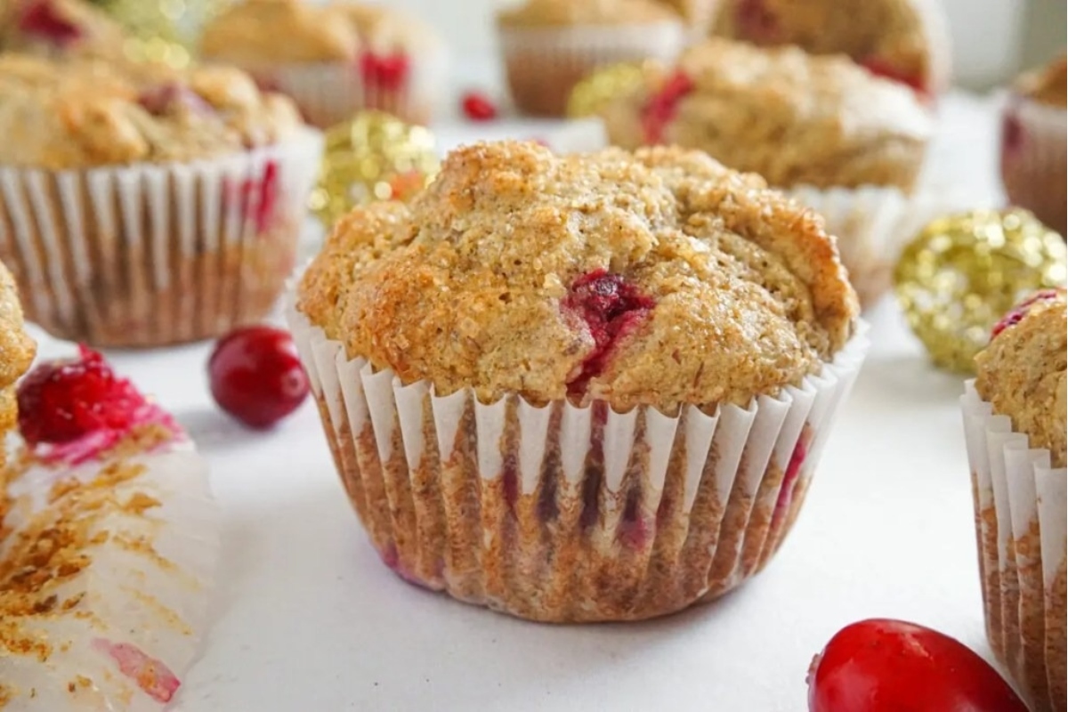 Snack recipe for cranberry muffins with cranberries on top.