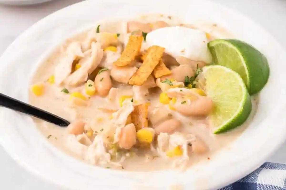 Chicken and white bean soup in a white bowl.