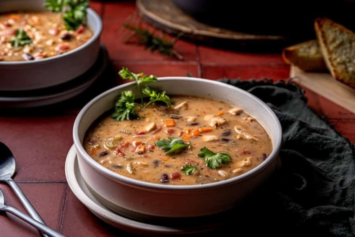 Two bowls of chicken stew on a red tiled floor.
