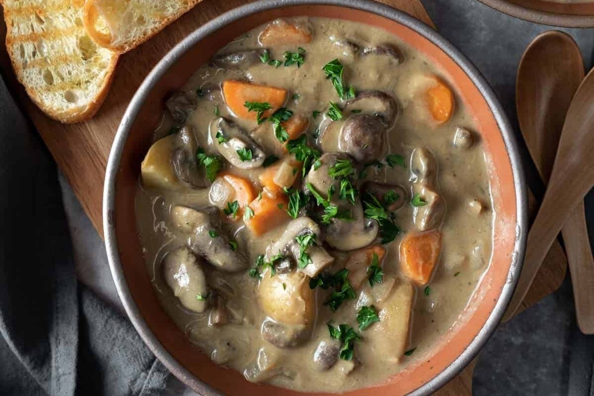 A comforting stew filled with mushrooms, potatoes, and served with warm bread.