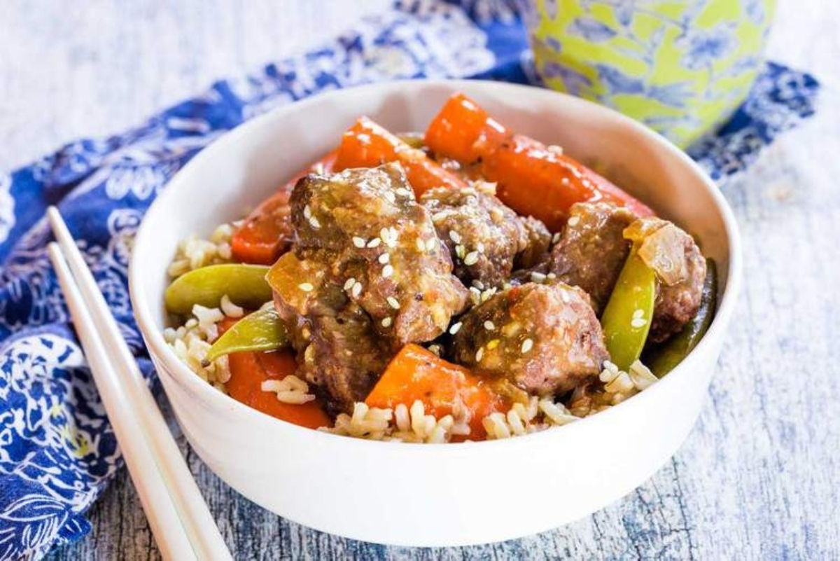 A Slow Cooker stew of meat and vegetables served with chopsticks.