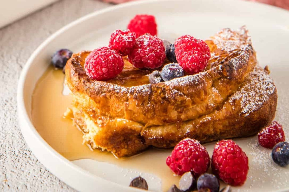 A delicious breakfast dish of french toast topped with fresh berries and a dusting of powdered sugar.