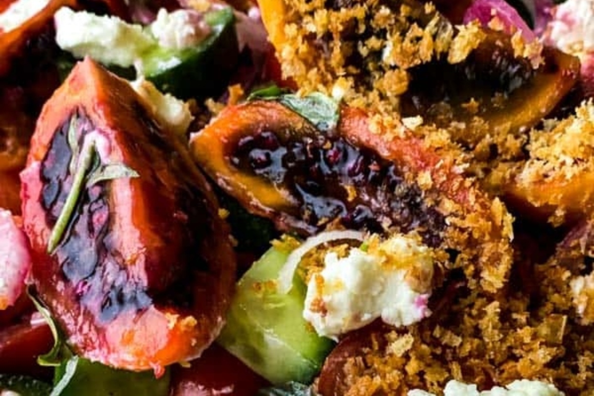 A plate with figs, tomatoes, cucumbers and goat cheese appetizers.