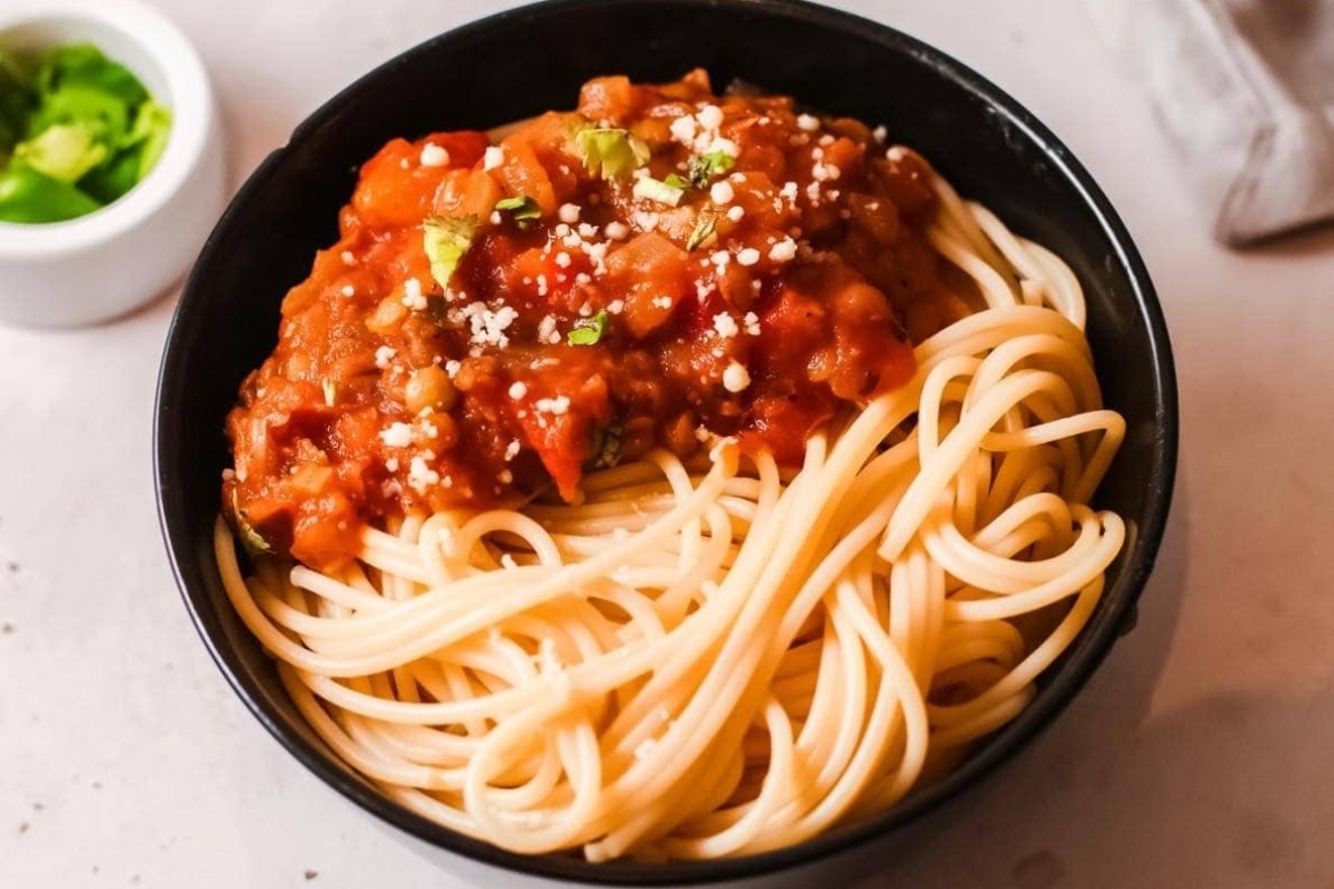 A delicious bowl of spaghetti with sauce and parmesan cheese.