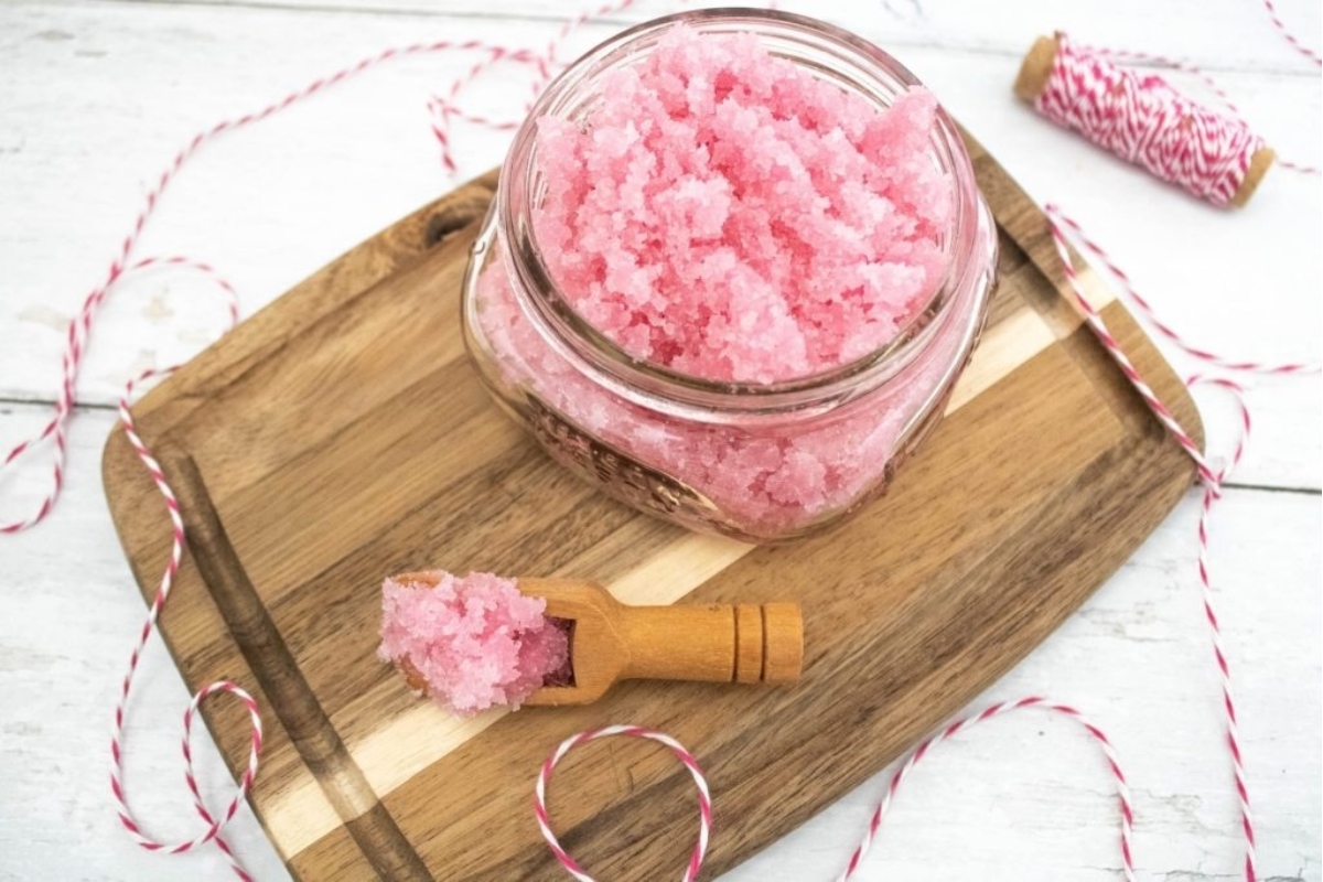 A jar of pink bath salts presented as a delightful gift on a wooden cutting board.