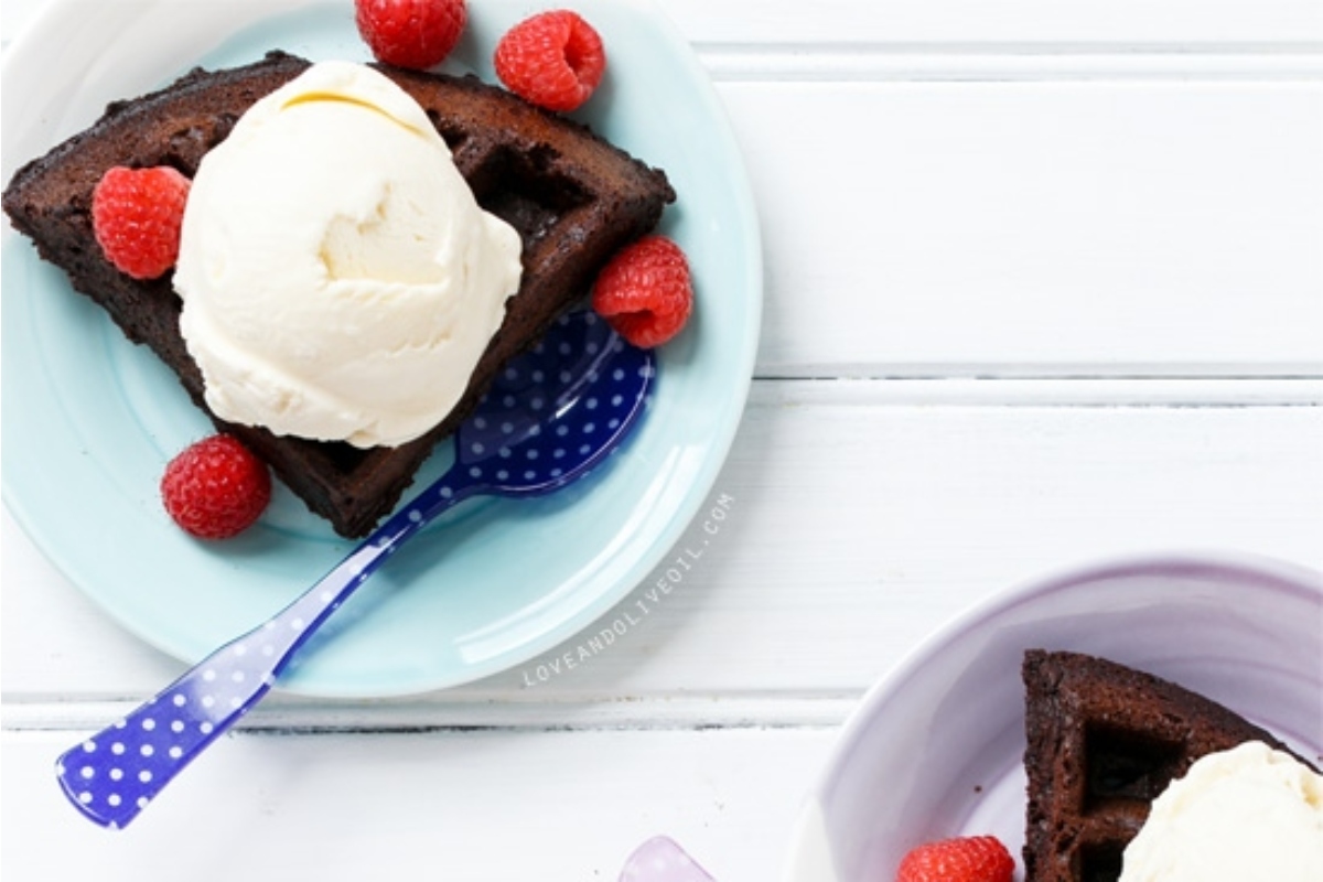 Indulge in decadent chocolate waffles topped with creamy ice cream and fresh raspberries.