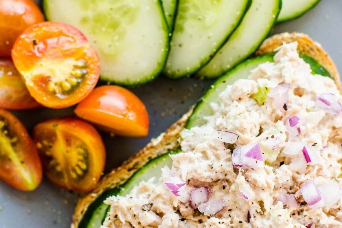 Tuna salad sandwich with tomatoes and cucumbers.