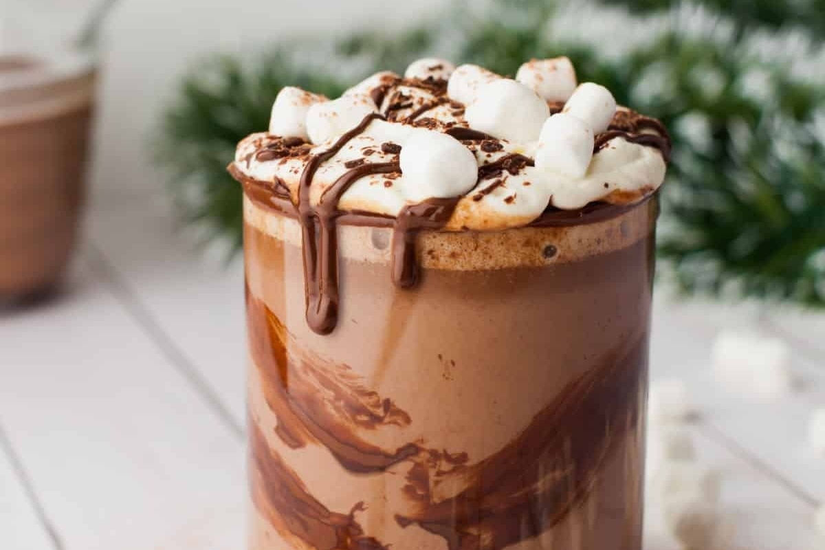 A cup of hot cocoa with marshmallows and whipped cream.