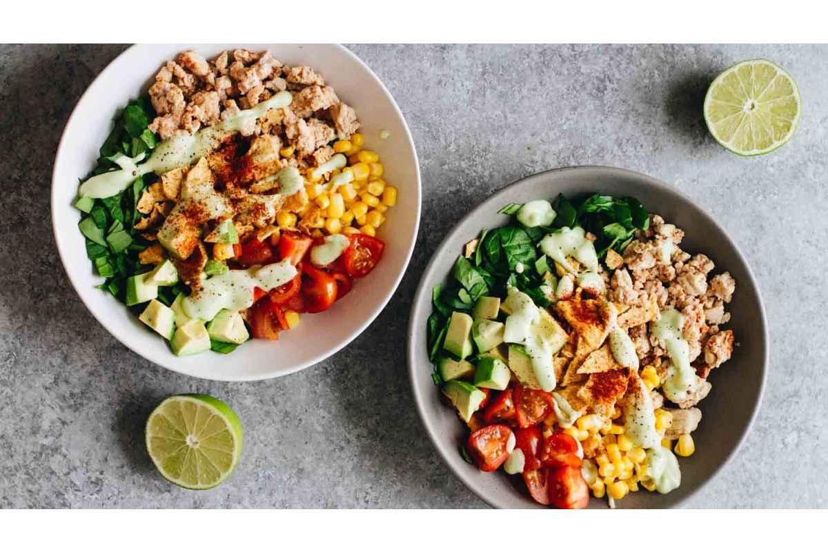 Two healthy lunches featuring high protein 
salads with tuna, corn, tomatoes, and limes.