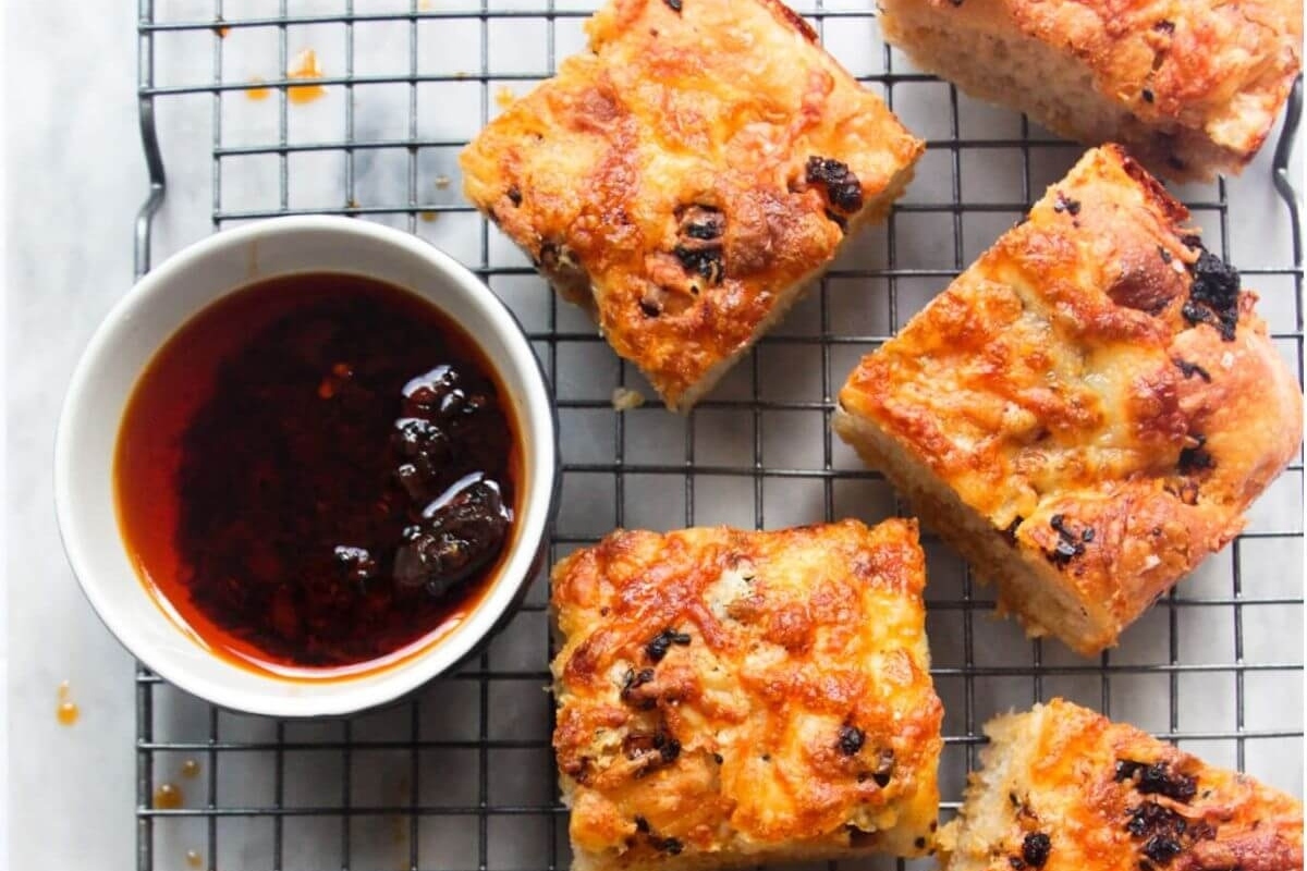 Focaccia bread with dipping sauce on a cooling rack.