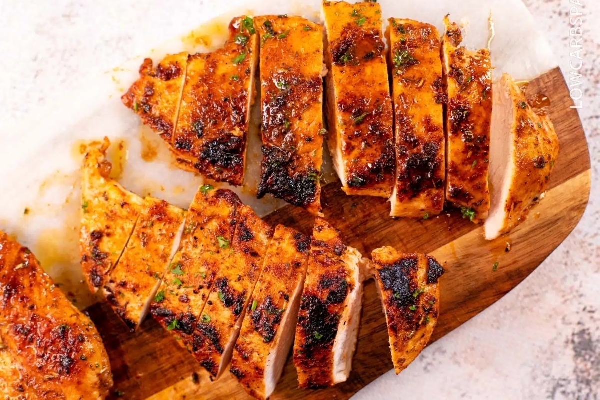 Love and family enjoy an inexpensive dinner of sliced chicken on a wooden cutting board.