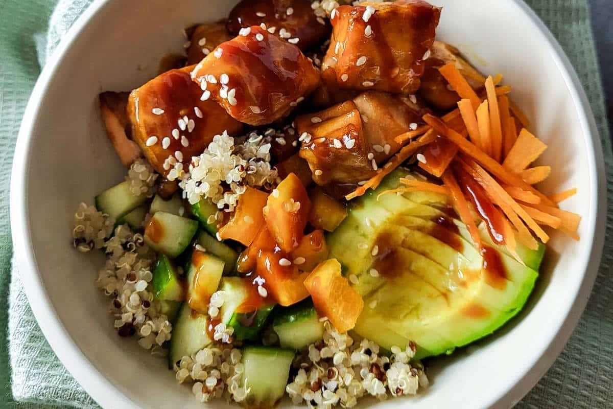 A delicious grain bowl recipe featuring asian quinoa with tender chicken and an array of fresh vegetables.