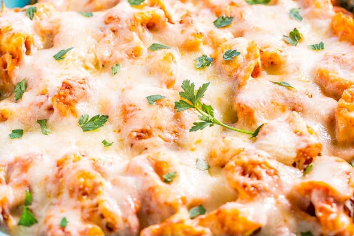 Cheesy tortellini casserole in a blue dish.